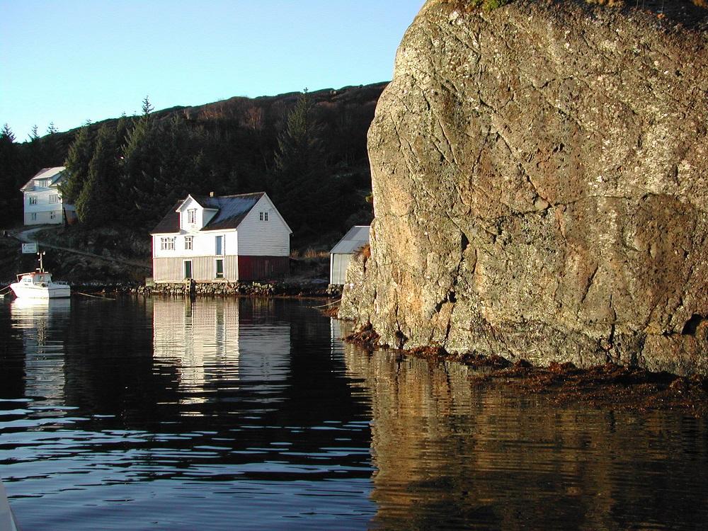 Vasstandsmerket i Nåra hamn er hogd inn i berghammaren på vestsida av Nårasundet, t. h. i biletet. Langtfrå alle plassar var det så ideelt å hogge inn merke som her. På fjære sjø kunne dei stå på "en flad Helle besat med Blæretang."