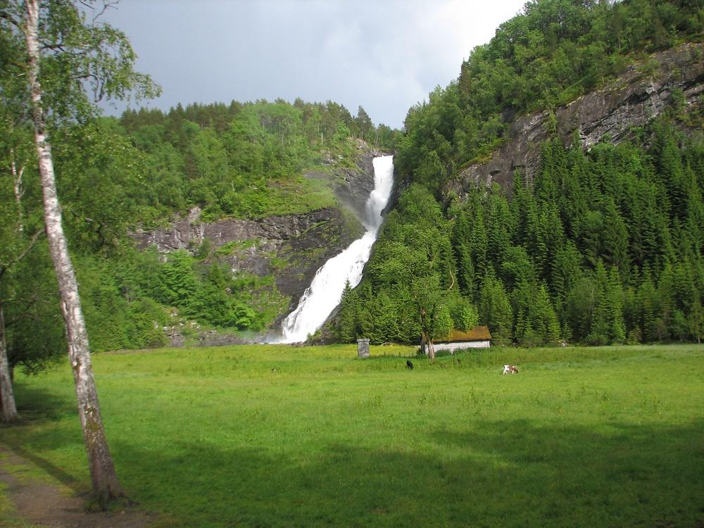 Huldefossen er perla i landskapet på Mo. Etter fossen renn Hulda ut i Jølstra (til venstre). Ein gong gjekk Jølstra tett innunder fossen og langs fjellfoten (til høgre).