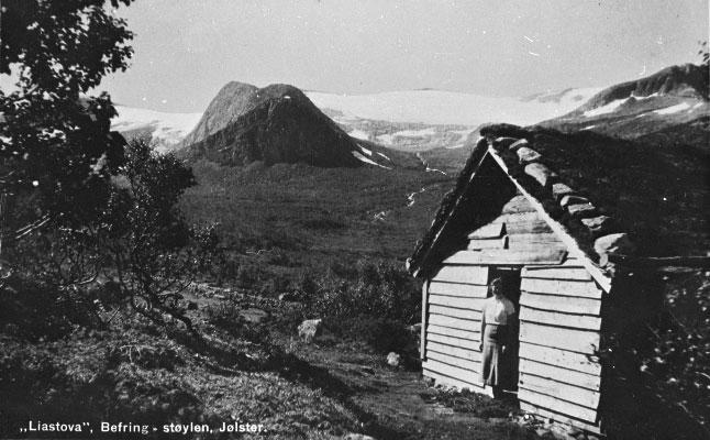 Postkort med Liastova på Befringsstøylen som motiv. Namnet til kvinna i døropninga kjenner vi ikkje til.
