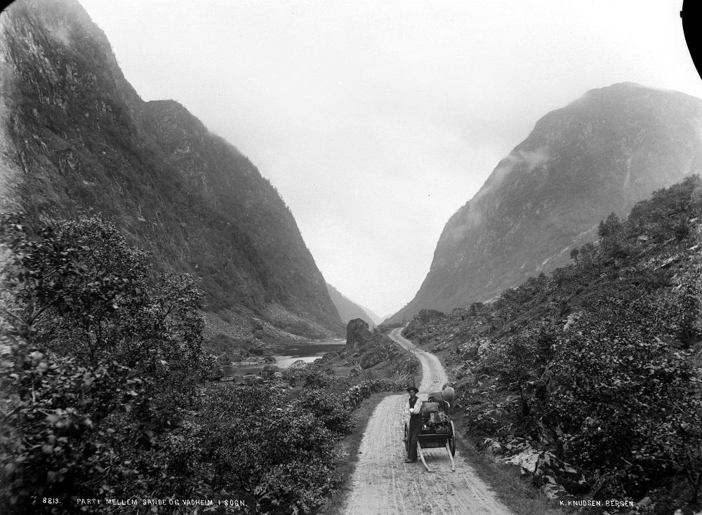 Her ser vi postvegen opp Ytredalen mot Økslandsvatnet. I 1856 uttalte fylkesvegnemnda at 'Veien gjennem Søndfjord og Nordfjord til Søndmøres grænse er Amtets vigtigste Veilinie, da den gaaer tvers igjennem samme, og Committeen antager, at man i den nærmeste Fremtid maa søge at bringe denne Linie i saa god Stand som muligt.'

 