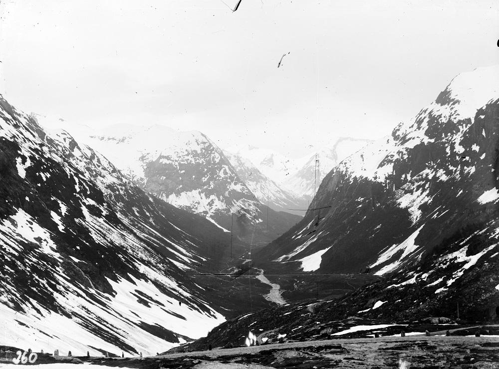 Kravet om heilårsveg over Strynefjellet kom frå postvesenet, og dei militære styresmaktene like etter at Strynefjellsvegen opna i 1896. Til vanleg var vegen farbar til midten av oktober. I gode år kunne dei greia å halda vegen open til 1. november. Vegdirektøren gav ingeniør Halfdan Pedersen ved vegkontoret i Sogn og Fjordane i oppdrag å vurdera spørsmålet om heilårsveg. Konklusjonen var at området ved Tystigen ville bli eit problem. Ein tunnel ville kosta 40 000 kroner. På den tida var det svært dy...