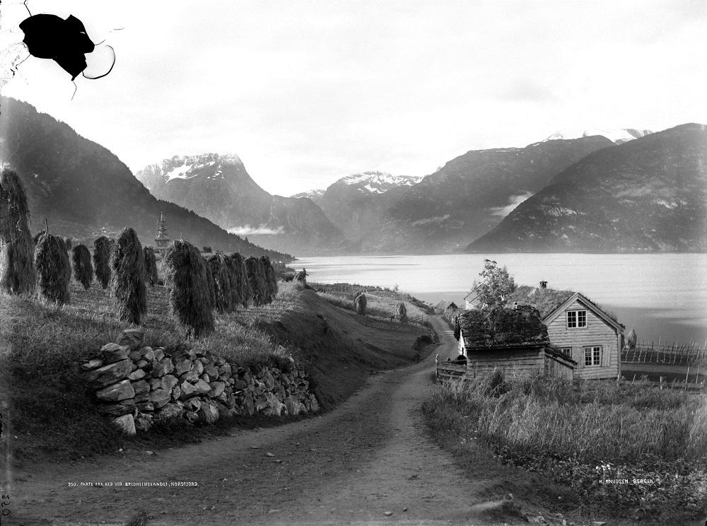 Postvegen på Reed med utsyn sørover Breimsvatnet. Vatnet ligg her speglande klårt, men det hende Breimsvatnet var umogeleg å fara. Ved sterk kastevind og isvanskar vinterstid, hende det at posten vart forseinka. Postopnar P. T. Reed skreiv ein gong at 'formedelst stærk synden Vind derfor maa Posten blive forsinket nogle Timer'. Det var sett opp svært nøyaktige tider for postruta mellom dei ulike poststadene. Postopnarane måtte føra detaljerte opplysningar om tilstanden for postsekken og innhaldet, o...