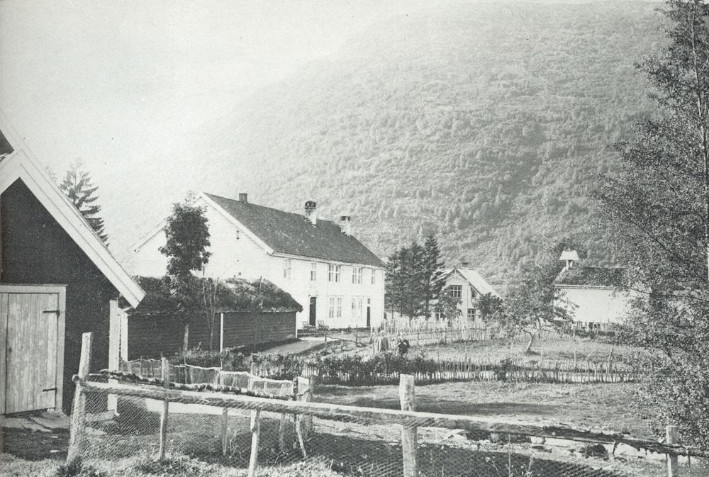 Gardstunet på sorenskrivargarden Løken i 1904. Det låge huset framfor hovudbygningen er borgstova, som vart riven i 1950-åra. Midt på biletet står sorenskrivar Brøgger og Anton Reed.
