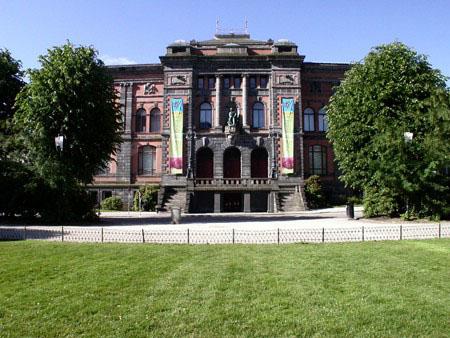 Statuen av J.C. Dahl står i frontpartiet på museet for kunsthåndverk og design, KODE1. Bygningen er frå 1896, og er best kjent som Permanenten, ei forkorting for det opphavlege namnet Den permanente utstillingsbygning.