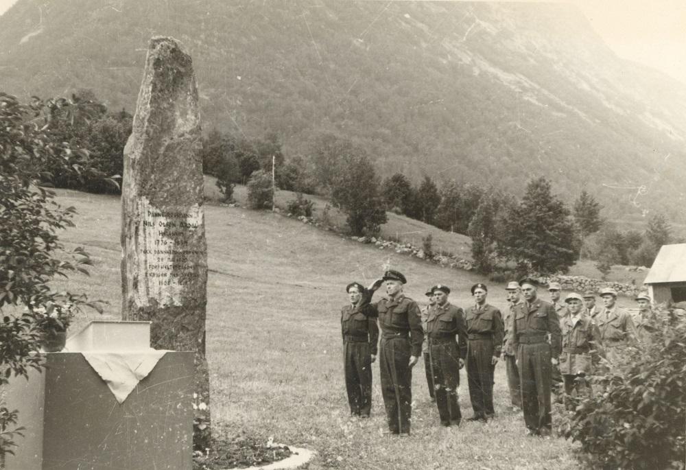 Frå avdukingshøgtida 5. juli 1964. Minnesteinen er avduka og ei tropp frå heimevernet i Jølster gjer honnør.
