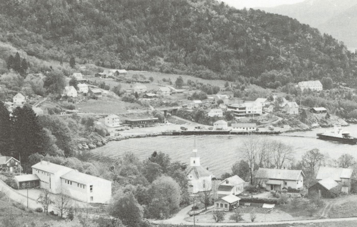 Kyrkjestaden Lavik i framgrunnen, og Kvammen, med ferjekai, butikk og hotell, på andre sida av vika. Helseheimen ligg oppe til høgre på biletet.
