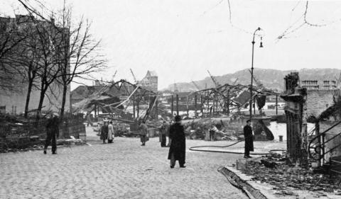 Patenebryggja og Nykirkekaiane etter eksplosjonsulukka på hamna i Bergen 20. april 1944. Den nederlandske lastebåten "Voorbode" kom inn på hamna lasta med "stykkgods" vart det sagt. "Stykkgodset" var i røynda 120 tonn dynamitt på veg til Kirkenes. Kl. 08.40 eksploderte lasta med eit brak som høyrdest over heile byen. Nils Aadland og Albert Hjertholm døydde. Kontorfunskjonær Elisa Moss vart blind då ho vart truffen av glassplintar. I alt miste rundt 150 menneske livet i eksplosjonskatastrofen 20. apr...