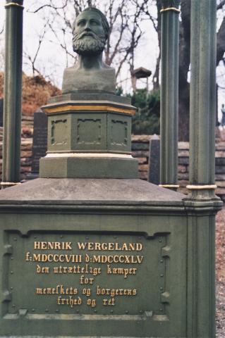 Utsnitt av minnesmerket på grava til Henrik Wergeland på Vår Frelsers gravlund i Oslo. Dette var det første av fleire minnesmerke over Wergeland. Det vart reist i 1849, fem år etter diktaren døydde, og vart kosta av takksame jødar busette i utlandet. Det står: HENRIK WERGELAND * f: [1808 med romertal] d: [1845 med romertal] * den utrættelige kæmper * for * meneskets og borgerens * frihed og ret