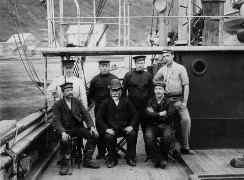 Dampskipet «Vangsnæs». Mannskap fotografert om bord på båten, kring 1908. Sitjande frå venstre: Anders Tansøy (matros), Johannes N. Vangsnæs (skipsførar). Dei andre ukjende.