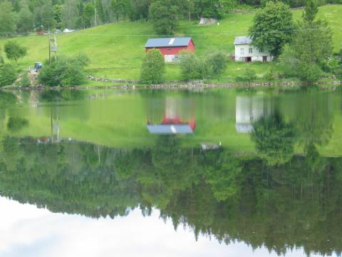 I enden av Bergavatnet låg ferje- og overnattingsstaden Berget. Løe/fjøs til venstre er kledd opp att. Dei to husa er frå ca. 1800. Staden fekk kongeleg brennevinsløyve i 1772, men drifta er eldre.