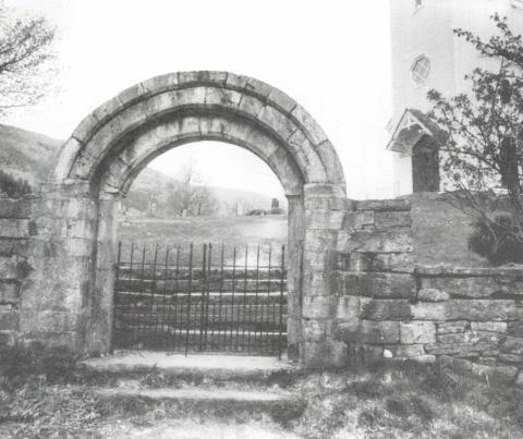 Den gamle korbogen i kleberstein er eit minne frå den gamle steinkyrkja i Naustdal. Denne vart riven i 1890 for å gi plass til den nye kyrkja. Korbogen er reist som inngangsport frå sørsida, og det var lenge skikk at alle som skulle gifte seg måtte gå gjennom denne på veg til kyrkja.