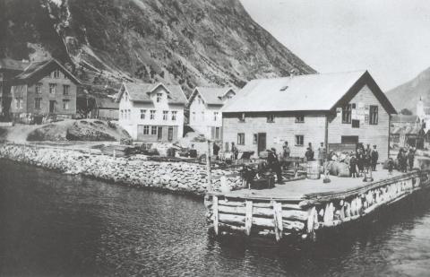 Dampskipsbryggja på Årdalstangen i 1917. I huset på kaien er det både dampskipsekspedisjon og butikk. Lengst til venstre ligg det store "Tangenhuset" der Jakob Dahl i 1909 starta hotelldrift. Mellom desse er bustadhuset til Dahl med butikk i kjellaren.
