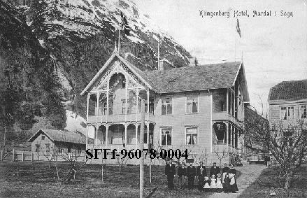 Den nye bygningen til Klingenberg hotell som stod ferdig i 1890. Det var Jens Klingenberg, Store-Jens, som på denne måten utvida hotelldrifta på Årdalstangen. Nede i høgre biletkant står 11 personar, mellom andre Jan Hille, som dreiv handel på Årdalstangen i perioden 1903 til 1928, og hotelleigar Jens J. Klingenberg, Vetle-Jens.
