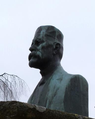 Jakob Sæthre på sokkel. Sokkelen er 140 cm høg med sider 80 cm. Skulpturen er signert «Sophus Madsen 1915».