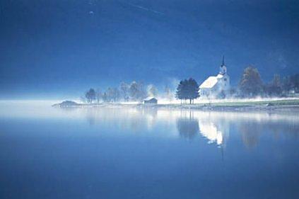 Oppstryn kyrkje ligg fint til på ei slette nede ved vatnet.