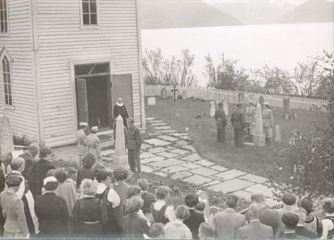 Kransnedlegging på krigsgravene ein 17. mai i 1950-åra. Lotter og heimevernsoldatar står æresvakt. Minnesteinen på Olav Rise si grav står på venstre side av vegen inn til kyrkja, minnesteinen til høgre står på Anders K. Eggum si grav.