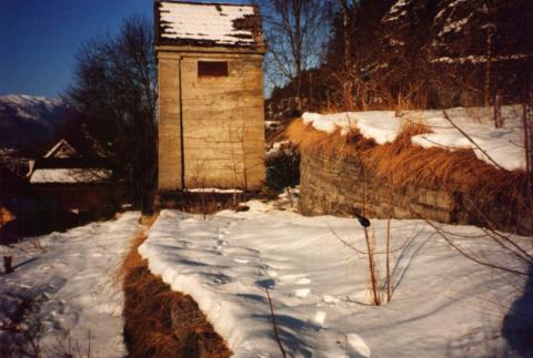 Biletet er teke mot vest. Terrenget rundt kiosken er terrasert med fine gråsteinsmurar.  Fjellet i området er skifrig, og det har difor vore forholdsvis lett å skaffe seg murstein.
