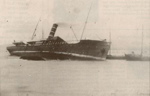 Hurtigruteskipet "Astrea" rende den 5. januar 1910 på Grasskjeret. Skipet var på nordgåande då det grunnstøytte 3 kabellengder aust-nordaust for Stabben fyr. Her ser vi skipet ståande på grunn på fluene ved Grasskjeret. Det ryk kraftig frå skorsteinen, så pumpene går for fullt. Ved skipssida er det fleire småbåtar i full sving med å redde det som reddast kan frå havaristen. Alle om bord vart redda, men skipet gjekk tapt.