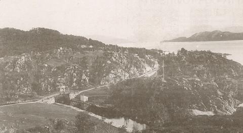 Her ser vi den gamle brua over kanalen kring 1900. Vegen frå Krokane går over brua og held fram rundt det som kom til å heite Kanalsvingen. Eidet var ikkje stort meir enn 100 meter tvers over, og det var ei stor lette for båttrafikken då Kanalen stod ferdig i 1873.