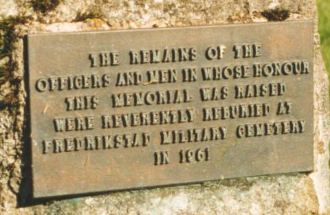 Innskrifta på norsk: Dei gravlagde offiserar og menige denne minnesteinen er reist til ære for, vart flytta til Fredrikstad militære kyrkjegard i 1961.